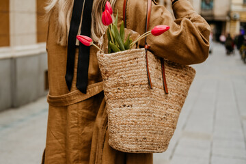 woman with pink tulips in bag flowers spring is coming pastel beige brown