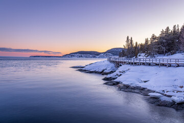 Obraz premium in Tadoussac the footbridge of the Pointe de l'Islet allows you to see whales. during a sunset in winter.