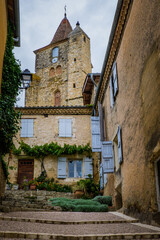 Fototapeta na wymiar View on the paved quaint street of Lavardens and the church bell tower in the South of France (Gers)