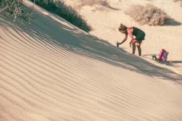 A tourist picks up sand from the beach, Fuerteventura, Canary Islands