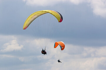 Paragliders flying in a cloudy sky
