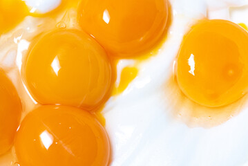 Egg yolks on whipped egg white foam. Close-up of broken eggs. - obrazy, fototapety, plakaty