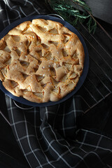 Delicious homemade dessert: appetizing baked apple pie sharlotka in baking form on dark background...