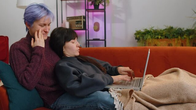 Two Lesbian Women Family Couple Or Girls Friends Closing Laptop Pc After Finishing Work At Home. LGBT People. Freelancers Working Online, Remote Job. E-learning, Browsing Internet On Notebook Computer