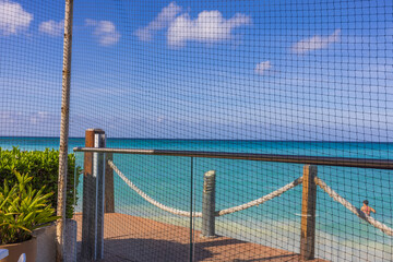 Beautiful view of territory of restaurant fenced with bird net against backdrop of Atlantic Ocean on island of Aruba.
