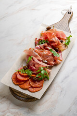 Italian Meat plate, parma ham, jamon, hamon, bresaola, chorizo on white marble table vertical