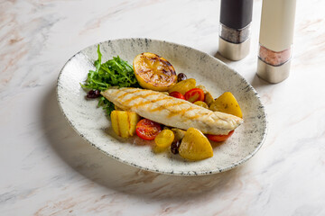 sea bass fillet with grilled vegetables and lemon on marble table - obrazy, fototapety, plakaty