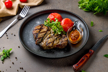 Fried pork loin steak with sauce on brown table