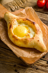 mini ajara Khachapuri with cheese, egg and butter, georgian kitchen on wooden table