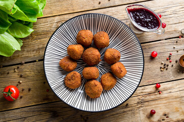 fried Cheese balls with berry sauce on old wooden table top view
