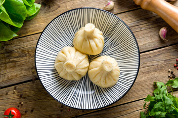 Khinkali with lamb on plate on wooden table top view