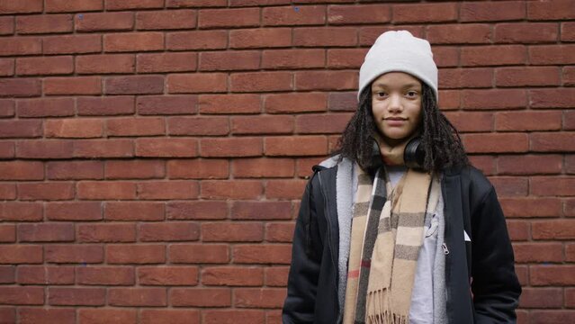 Portrait of teenager in a beanie hat looking to camera with no expression, with space for text