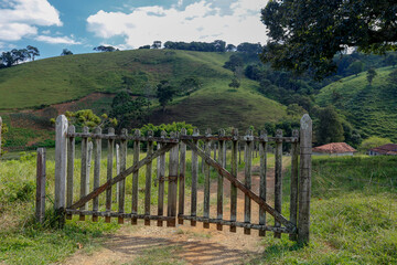 Fototapeta na wymiar Farm gate with trees and grass on background. Countryside of Sao Paulo state, Brazil