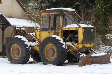 Maszyna do leśnych prac , buldożer lub równiarka. Maszyna zaparkowana na zaśnieżonym terenie .