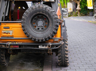Rear view orange jeep parked on street in Bali
