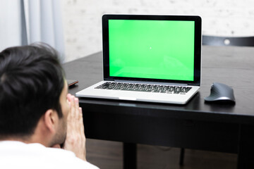 Back view on shocked man working on laptop. Green Screen and space for text concept