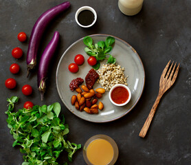 Vegan meal, vegan restaurant, salad, tomatoes, almonds, cereals, soy sauce, on a black table, healthy food concept, flat lay