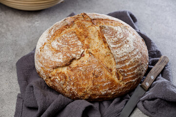 Traditional wheat rustic sourdough bread on a stone table.