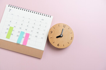 close up of calendar and clock on the pink table background, planning for business meeting or travel planning concept