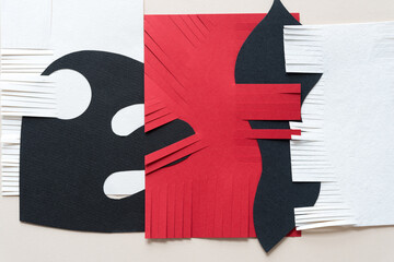 combined white, black, and red abstract paper shapes - some with fringe edges - on blank paper