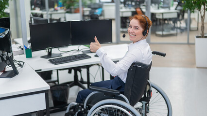 Caucasian woman in wheelchair showing thumb up while sitting in open space office.