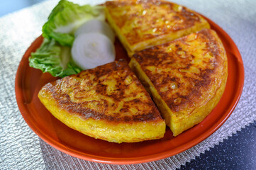 Spanish vegetarian food, portion of homemade tasty potato omelette tortilla de patatas with onion served in morning sunlights