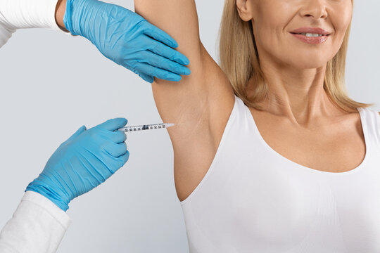 The doctor makes intramuscular injections in the underarm area