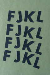 letter f, j, k, l on rough green paper