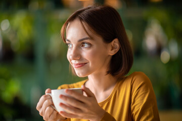 Closeup of pretty young woman holding coffee mug