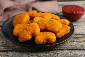 Tasty chicken nuggets on wooden table, closeup