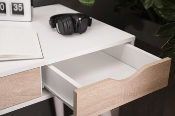 Stylish desk with open empty drawer in office