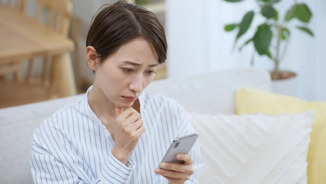 スマホを見て考える女性