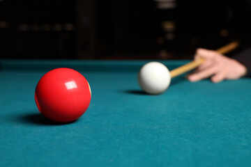 Man playing billiard at green table, closeup. Space for text
