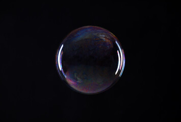 One beautiful soap bubble on black background