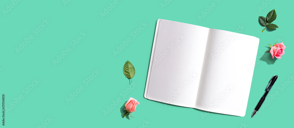 Poster open notebook or diary with a pen from above with rose buds- flat lay
