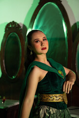 a entertainer woman with a green dress and scarf posing very beautiful and exotic in front of a...