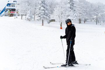 Young Asian man with practicing skiing on snowy mountain slope at in ski resort. Handsome guy enjoy winter activity outdoor active lifestyle extreme sport training freeride ski on holiday vacation.