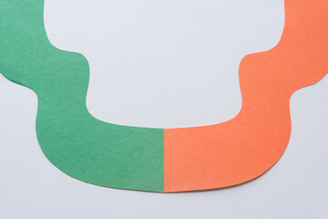 green and orange paper ribbon on blank paper