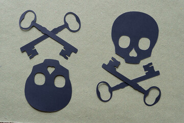 two black paper skull cutouts with old fashioned key-shaped crossbones 