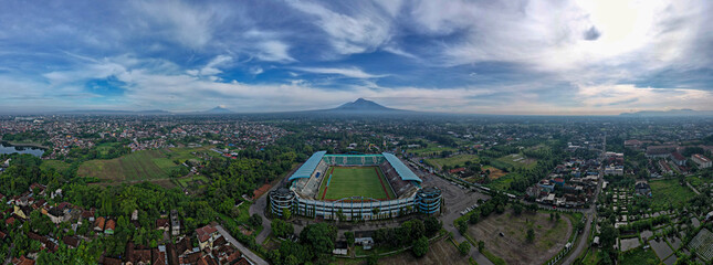 Sleman Yogyakarta, April 6, 2022 : View of Maguwoharjo Stadium from the air on a sunny morning. view of the stadium against the backdrop of the majestic Mount Merapi. 