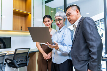 Team of Asian people with different age group brainstorming on data and information analysis for strategy management with young female leader for cooperation and business concept