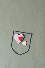 heraldry shield or simple banner frame with wooden hearts on rough green paper