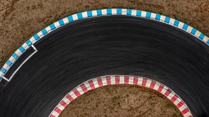 Foto auf Glas Aerial top view motorsport race asphalt track circuit motor racing track, Race track curve, Curving race track view from above, Aerial view car race asphalt track and curve. © Kalyakan