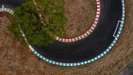 Aerial top view motorsport race asphalt track circuit motor racing track, Race track curve, Curving race track view from above, Aerial view car race asphalt track and curve. © Kalyakan