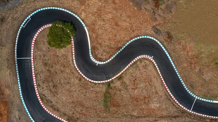 Foto auf Acrylglas Aerial top view motorsport race asphalt track circuit motor racing track, Race track curve, Curving race track view from above, Aerial view car race asphalt track and curve.  © Kalyakan