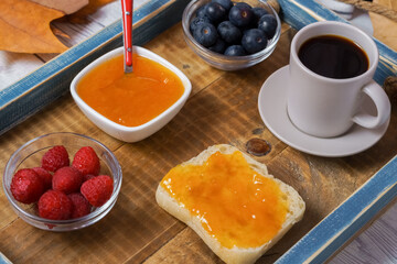 healthy breakfast on a wooden tray,homemade jam,berries and coffee