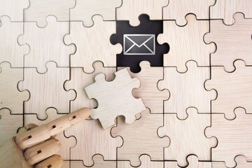 wooden puzzle with an unopened Email icon. email support concept. the concept of email and the concept of communication through email