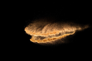 Brown color sand splash against black background. Sand fly wave in the air.