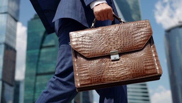 An unrecognizable businessman or lawyer in an official suit with a briefcase in the central offices of the company or in the government building.