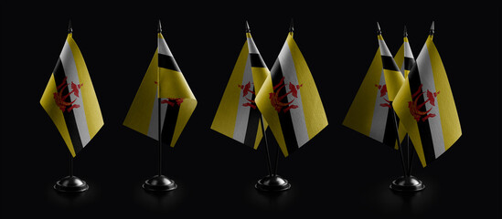 Small national flags of the Brunei on a black background
